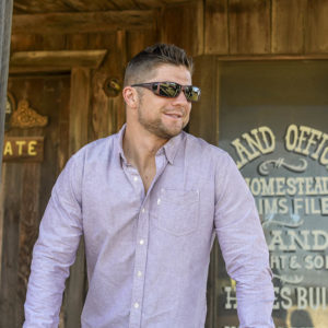 Dustin Jon is wearing polarized burgundy Cocoons over his eyeglasses to shield his eyes from the sun.
