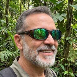 Image of man wearing Cocoons fitover sunglasses model C707R in heavily wooded area